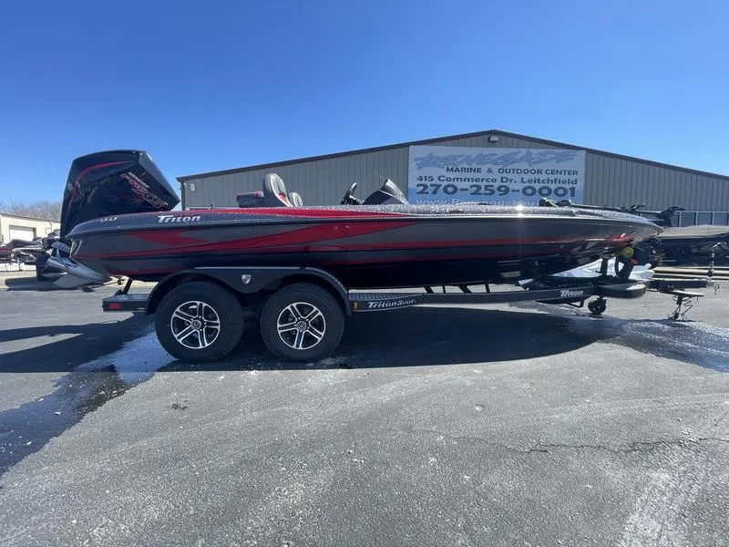 The Image of 2024 Triton 21 TrX Patriot boat on a trailer outside a marine center. - 1