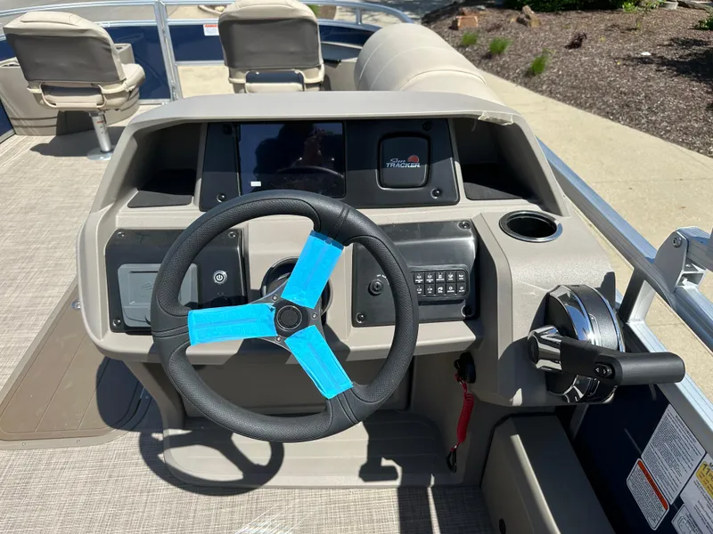 Slide: The Image of 2024 Sun Tracker Fishin' Barge 22 XP3 helm with steering wheel and control panel. - 6