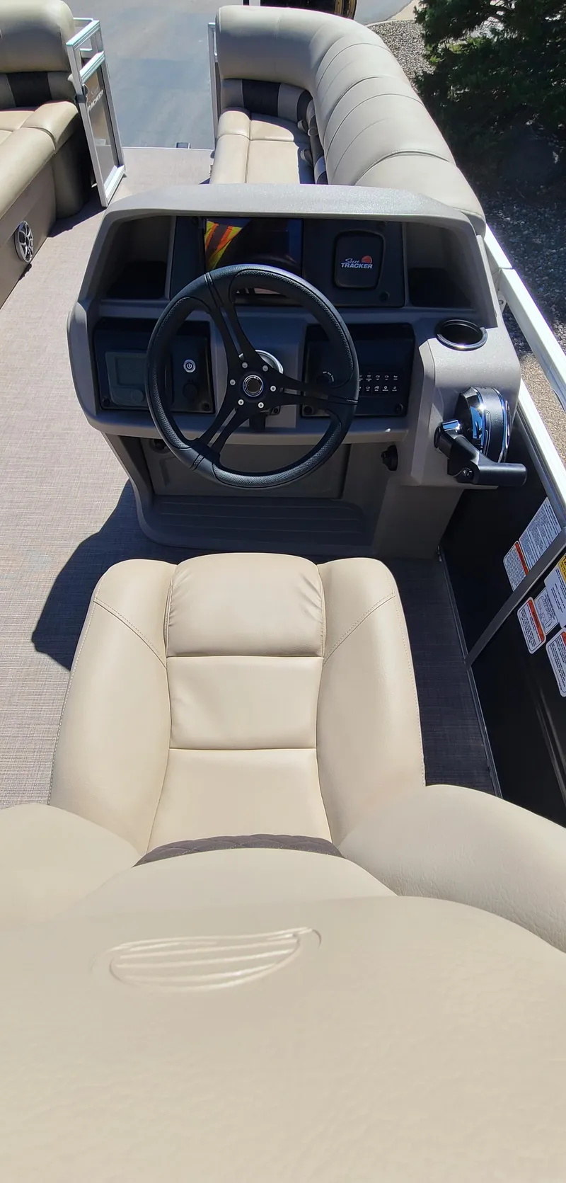 Slide: The Image of 2024 Sun Tracker Party Barge 24 DLX helm with beige captain's chair and steering wheel. - 6