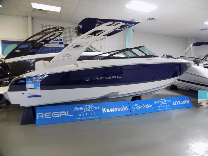 Slide: The Image of 2024 Regal LX2 boat displayed indoors with promotional signage. - 1