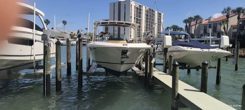 Slide: The Image of 2015 Chris-Craft Catalina 29 docked at a marina with waterfront buildings in the background. - 1