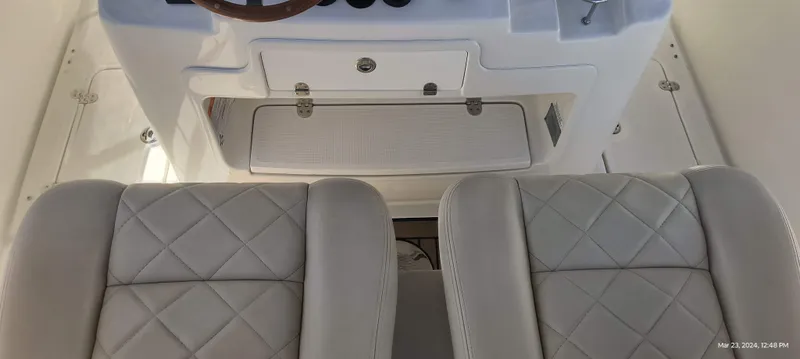 Slide: The Image of 2015 Chris-Craft Catalina 29 interior with white diamond-stitched seats and dashboard. - 17