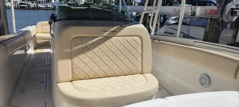 Slide: The Image of 2015 Chris-Craft Catalina 29 boat interior with beige diamond-stitched seating. - 22