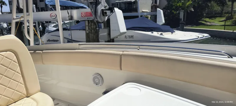 Slide: The Image of 2015 Chris-Craft Catalina 29 interior with beige seating, docked near other boats. - 24
