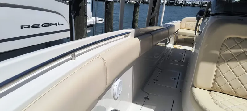 Slide: The Image of 2015 Chris-Craft Catalina 29 boat interior with beige seating at a marina. - 26