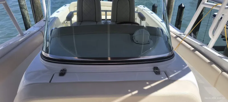 Slide: The Image of 2015 Chris-Craft Catalina 29 boat with windshield and seating, docked by the water. - 34