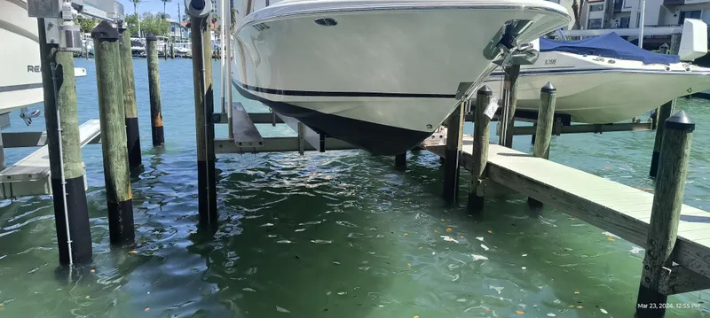 Slide: The Image of 2015 Chris-Craft Catalina 29 boat docked on a lift over clear water. - 40