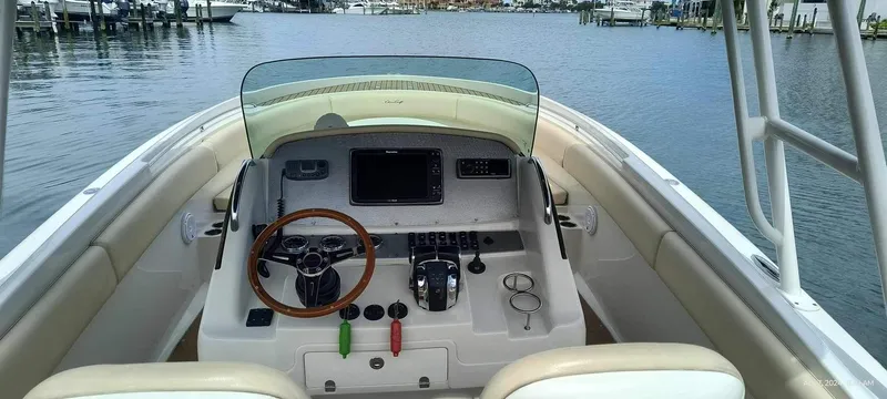 Slide: The Image of 2015 Chris-Craft Catalina 29 helm station with wooden steering wheel and modern controls. - 48