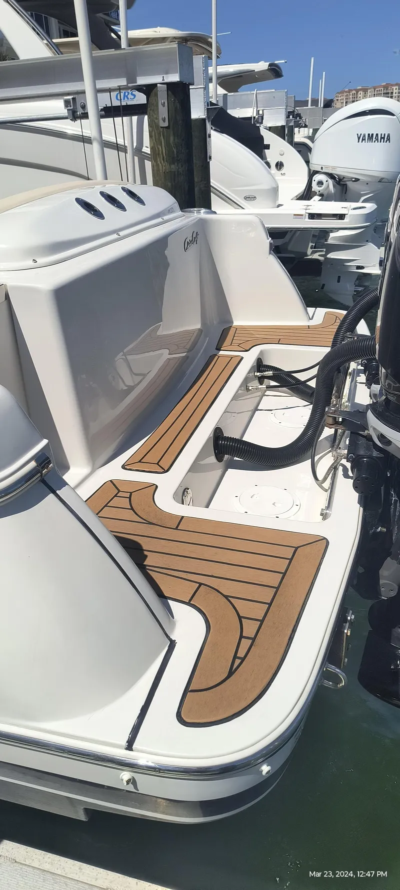 Slide: The Image of 2015 Chris-Craft Catalina 29 boat docked, showcasing teak deck and outboard engines. - 5