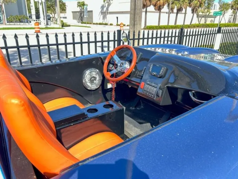 Slide: The Image of Interior of 2023 Watersports Car Series M with orange seats and red steering wheel. - 2