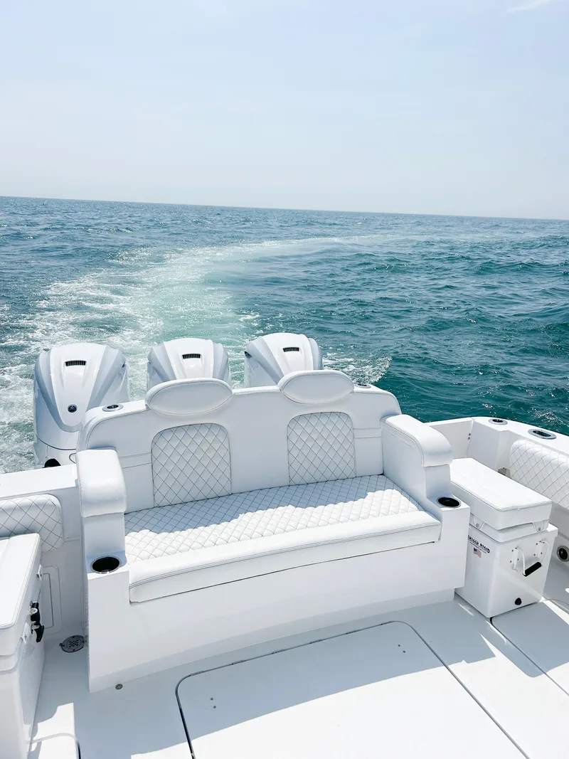 Slide: The Image of 2024 HCB 42 Lujo luxury boat with triple engines on open water. - 13