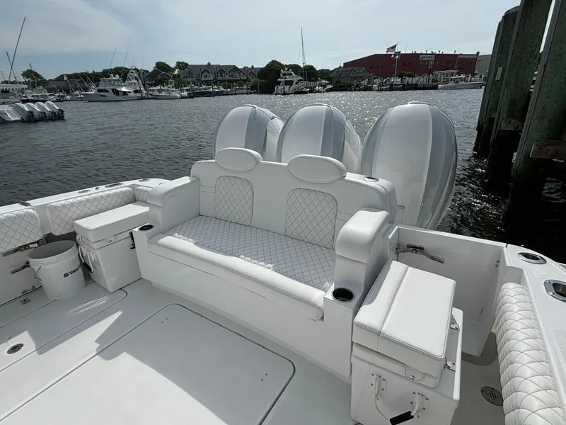 Slide: The Image of 2024 HCB 42 Lujo luxury boat with white seating and powerful outboard engines. - 18