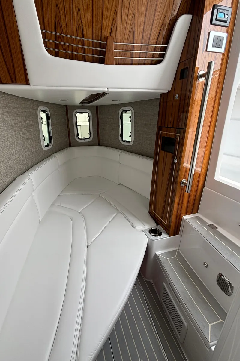 Slide: The Image of 2024 HCB 42 Lujo cabin interior with white seating and wood accents. - 29