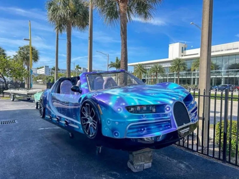 Slide: The Image of 2023 Watersports Car Series B with vibrant blue design on display outdoors. - 1