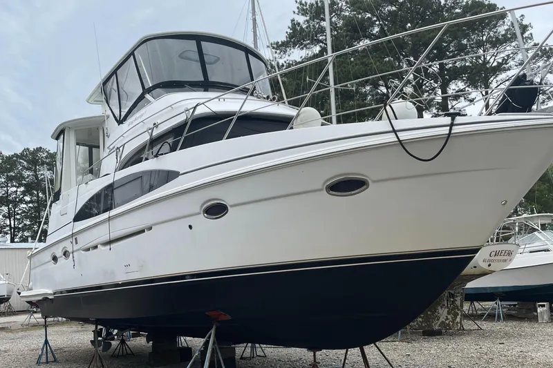 Slide: The Image of 2002 Carver 444 Cockpit Motoryacht on stands in a boatyard. - 1