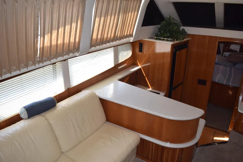 Slide: The Image of Interior of 2002 Carver 444 Cockpit Motoryacht with cream leather seating and wooden cabinetry. - 13