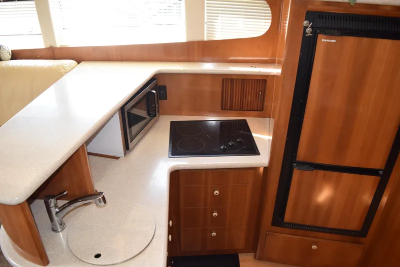 Slide: The Image of 2002 Carver 444 Cockpit Motoryacht kitchen with stove, microwave, and refrigerator. - 15