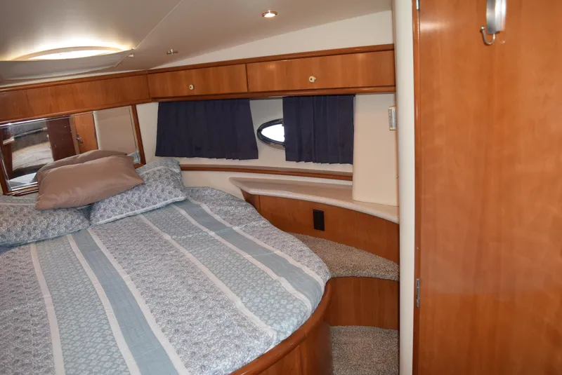 Slide: The Image of 2002 Carver 444 Cockpit Motoryacht bedroom with wood cabinetry and striped bedding. - 17