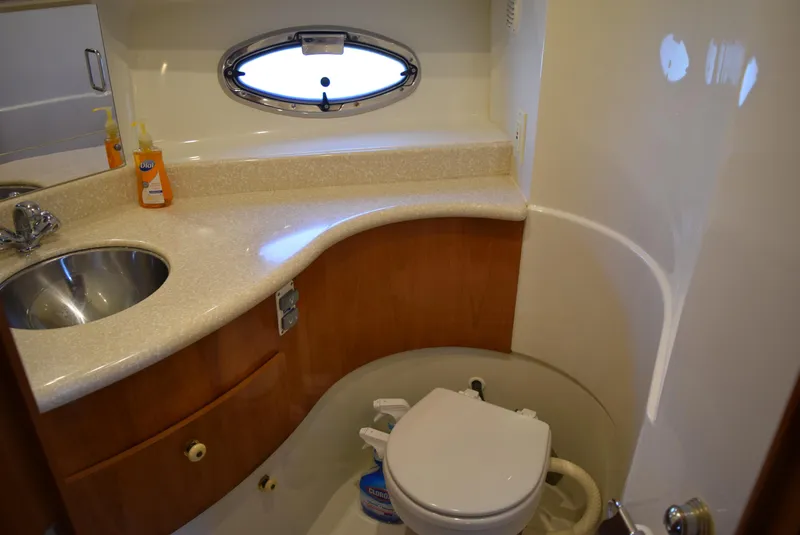 Slide: The Image of 2002 Carver 444 Cockpit Motoryacht bathroom with sink, toilet, and porthole window. - 19