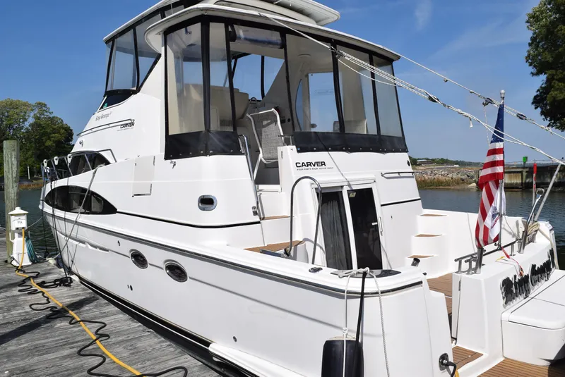 Slide: The Image of 2002 Carver 444 Cockpit Motoryacht docked, rear view with American flag. - 3