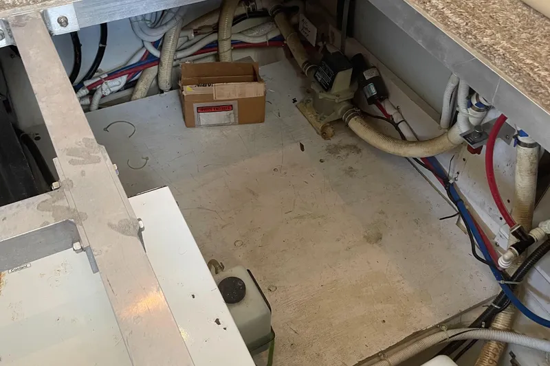 Slide: The Image of Engine compartment of a 2002 Carver 444 Cockpit Motoryacht with various hoses and equipment. - 32