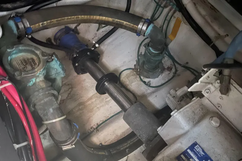 Slide: The Image of Engine compartment of a 2002 Carver 444 Cockpit Motoryacht showing hoses and mechanical components. - 36