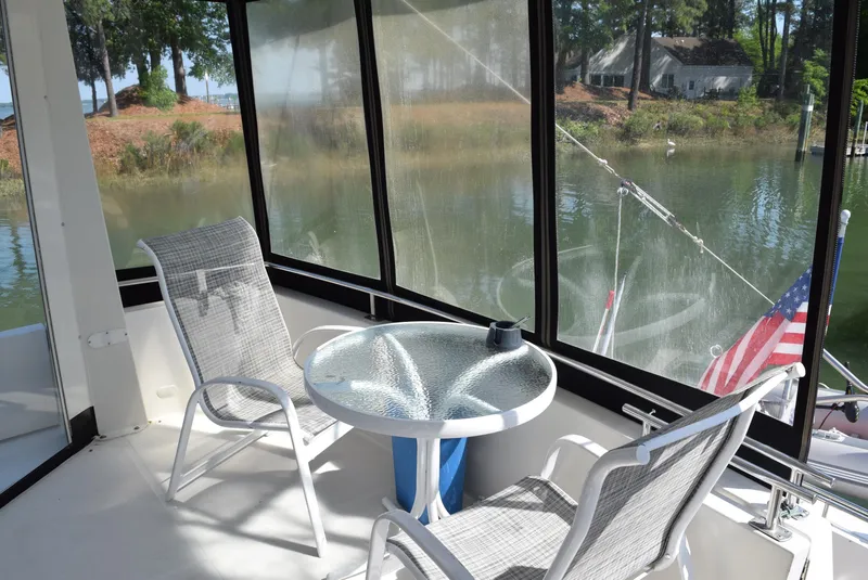 Slide: The Image of Enclosed deck area on 2002 Carver 444 Cockpit Motoryacht with table and chairs. - 7