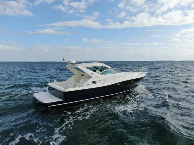 Slide: The Image of Uniesse 42 Open 2001 yacht cruising on open water under a partly cloudy sky. - 2