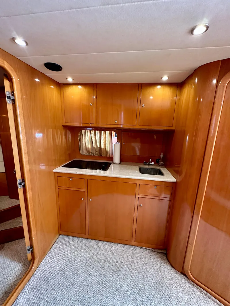 Slide: The Image of 2001 Uniesse 42 Open yacht kitchen with wooden cabinetry and modern appliances. - 26