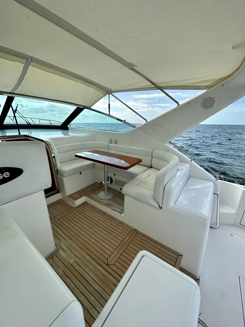 Slide: The Image of 2001 Uniesse 42 Open yacht interior with white seating and wooden table. - 45