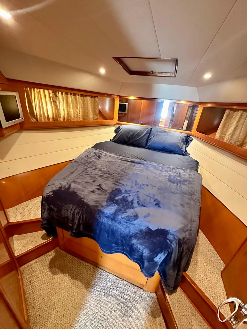 Slide: The Image of 2001 Uniesse 42 Open yacht bedroom with cozy bed and elegant wood finish. - 9