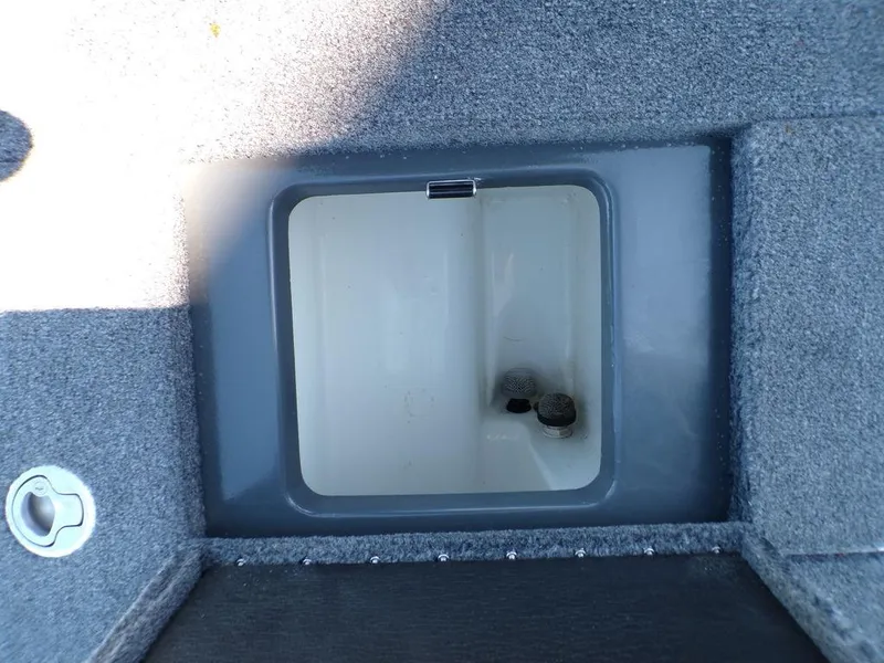 Slide: The Image of Phoenix 920 Elite 2023 boat storage compartment with gray carpeted interior. - 35