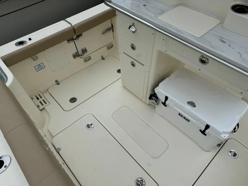Slide: The Image of Interior of 2025 Scout 260 LXF boat with storage compartments and cooler. - 13