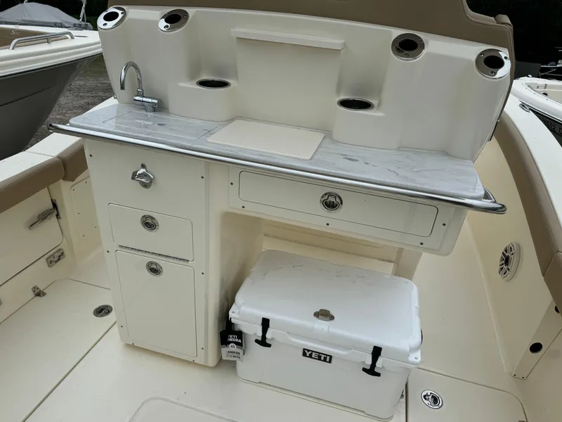 Slide: The Image of 2025 Scout 260 LXF boat interior with sink, storage, and Yeti cooler. - 14