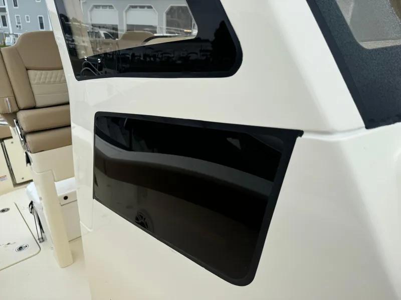 Slide: The Image of 2025 Scout 260 LXF boat interior with beige seating and sleek black window. - 26