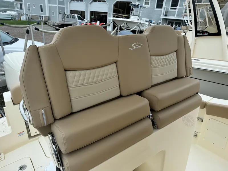 Slide: The Image of 2025 Scout 260 LXF boat with luxurious tan seating in a marina. - 27