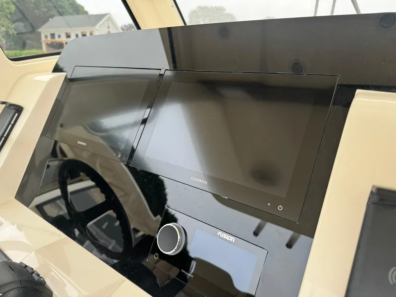 Slide: The Image of 2025 Scout 260 LXF boat dashboard with Garmin displays and Fusion control. - 30