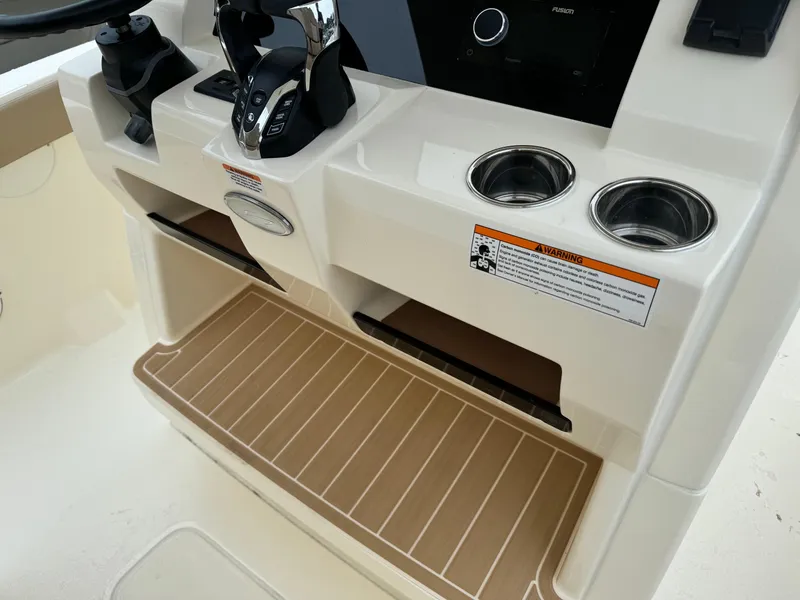 Slide: The Image of 2025 Scout 260 LXF boat console with controls, cup holders, and footrest. - 31