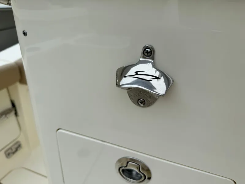 Slide: The Image of Close-up of a 2025 Scout 260 LXF boat's bottle opener and storage compartment. - 35