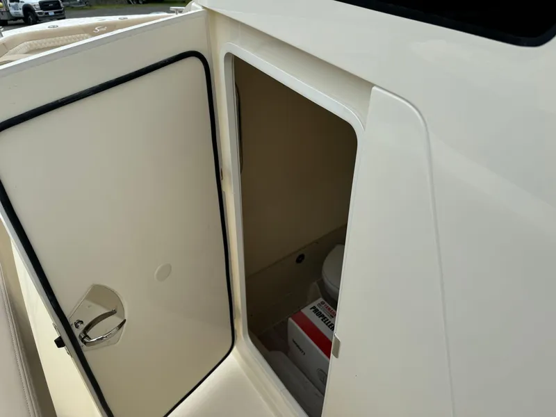 Slide: The Image of 2025 Scout 260 LXF boat interior storage compartment with open door. - 37