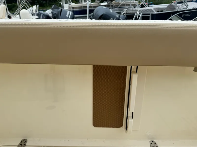 Slide: The Image of 2025 Scout 260 LXF boat interior detail with beige upholstery and storage compartment. - 46