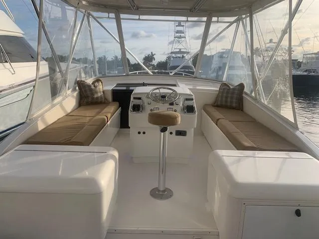 Slide: The Image of 2004 Stolper 38 boat interior with helm, cushioned seating, and marina view. - 13