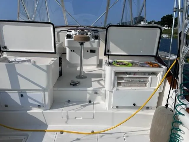 Slide: The Image of 2004 Stolper 38 boat cockpit with open storage compartments and steering wheel. - 19
