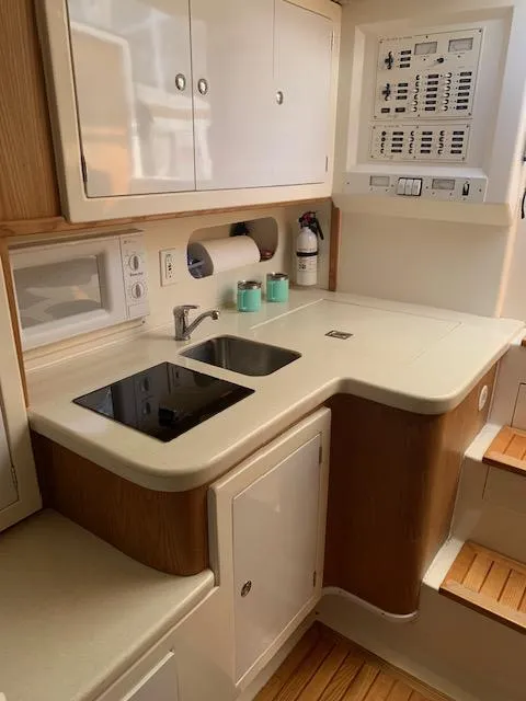 Slide: The Image of Compact kitchen area in a 2004 Stolper 38 boat with sink, stove, and storage cabinets. - 9