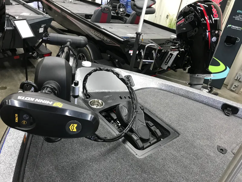 Slide: The Image of 2024 Ranger Z519 boat on a trailer outside a garage. - 2