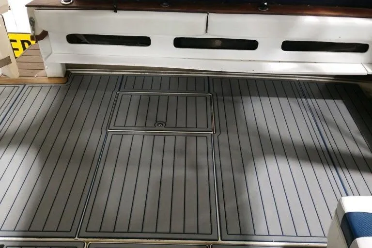 Slide: The Image of 1986 Sea Ray 390 Express boat deck with gray and blue striped flooring. - 11