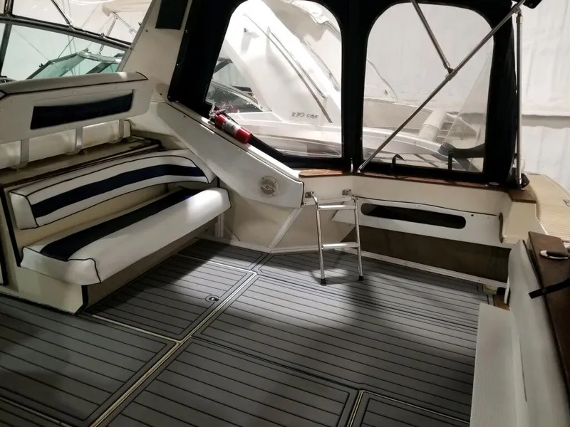 Slide: The Image of 1986 Sea Ray 390 Express boat interior with seating and gray flooring. - 15