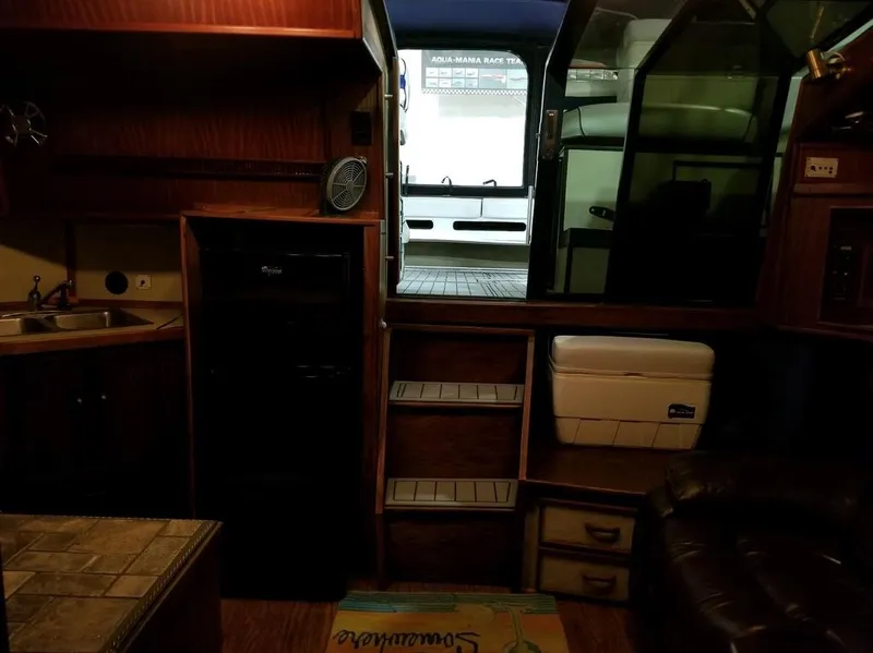 Slide: The Image of Interior of 1986 Sea Ray 390 Express boat with kitchenette and seating area. - 18