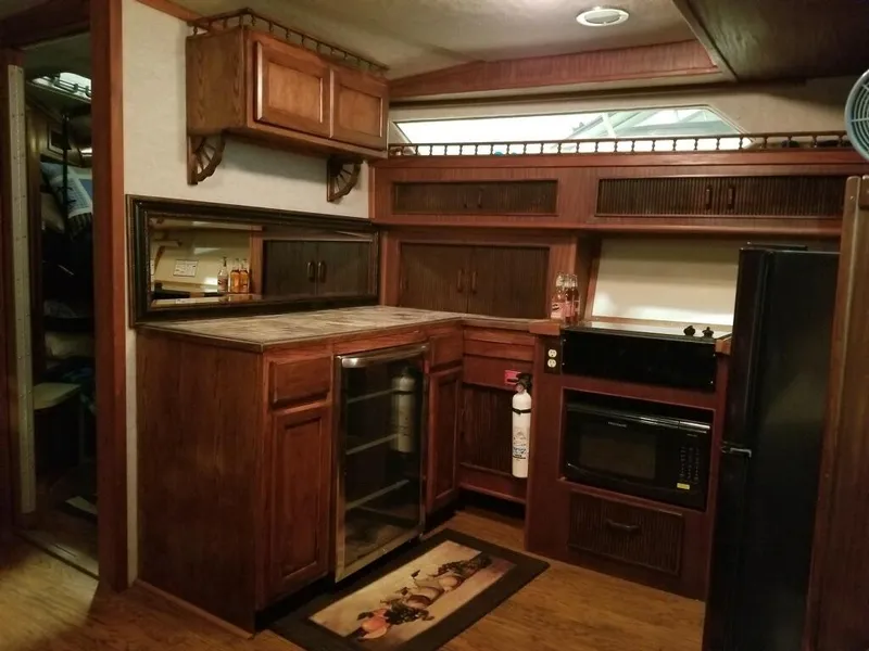 Slide: The Image of 1986 Sea Ray 390 Express yacht kitchen with wooden cabinets and modern appliances. - 21
