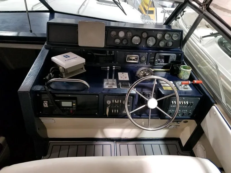 Slide: The Image of 1986 Sea Ray 390 Express boat helm with steering wheel and control panel. - 26